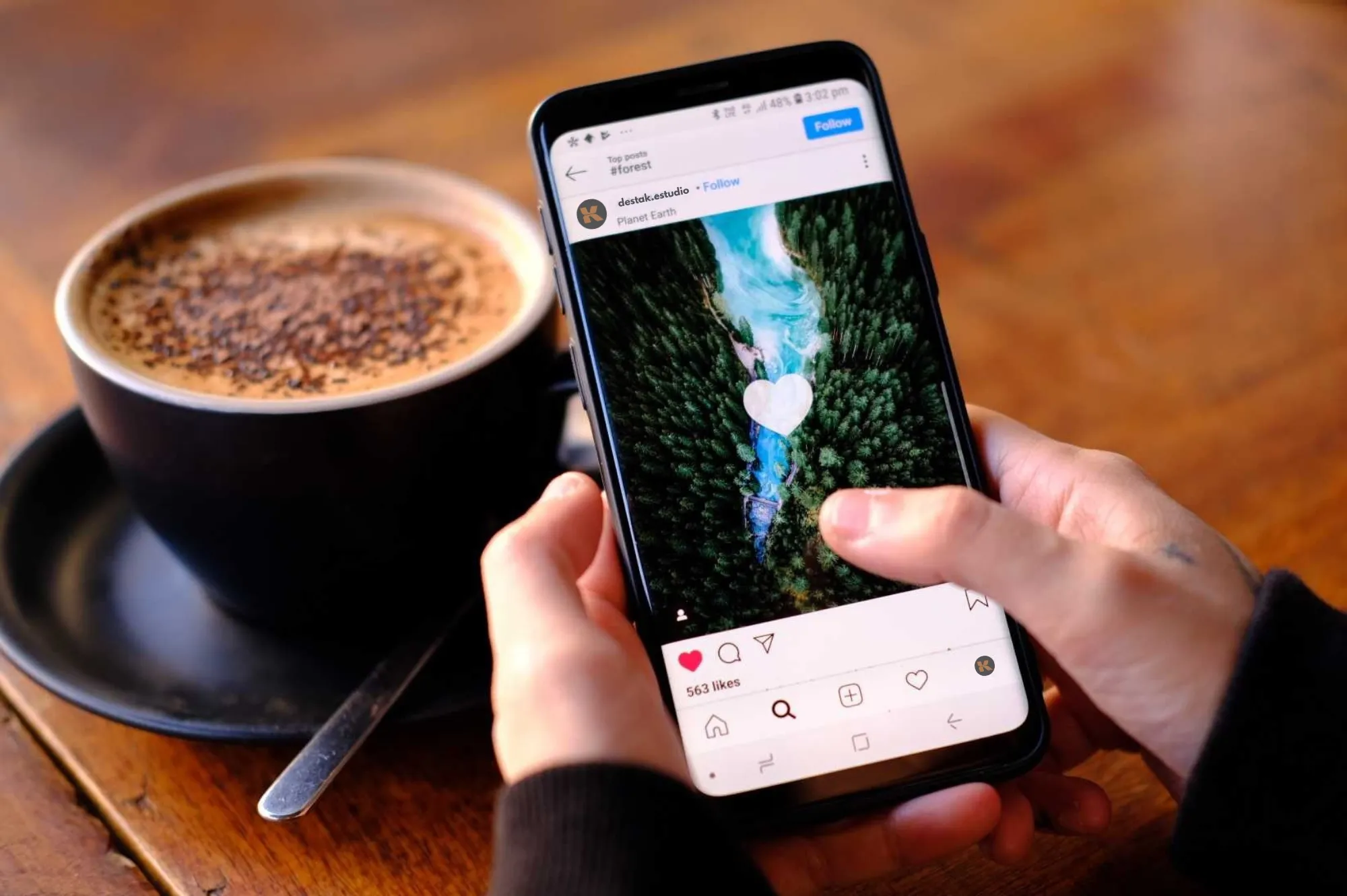 Taza de café caliente mientras revisa contenido audiovisual de cómo generar visitas en redes sociales